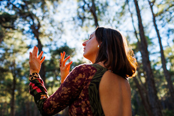 Concept of balance, harmony and health. girl alone with nature. a girl dances and sings in the forest among the trees.