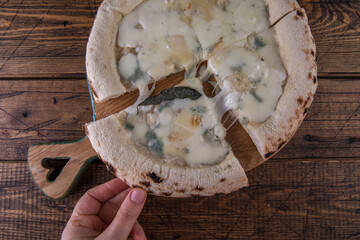 Neapolitan pizza 4 cheeses on a wooden board on a wooden background