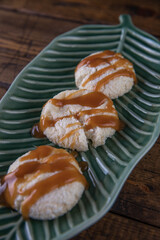 Cheesecakes with caramel sauce on a plate on a wooden table