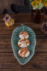 Cheesecakes with caramel sauce on a plate on a wooden table