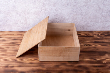 Wooden box with cover on a wooden table.