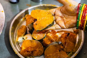 fresh fish marinating in spices at home in plat from different angle