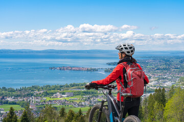 happy, active senior woman cycling above Lake Constance, Bodensee and  admiring the awesome view...