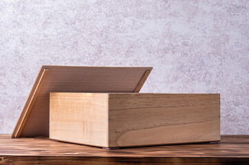 Wooden box with cover on a wooden table.