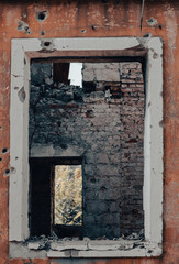 empty window of a destroyed house in Ukraine
