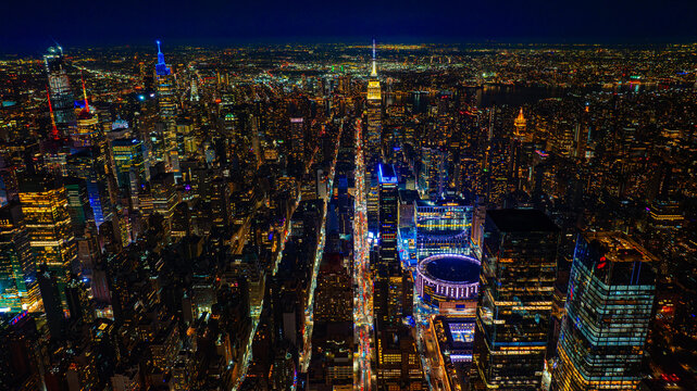 Immense luminous panorama of night New York, USA. Lively metropolis downtown from top.