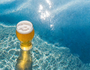 bicchiere di birra chiara mentre galleggia nel mare limpido - obrazy, fototapety, plakaty