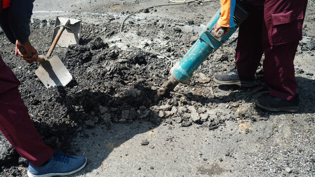 workers are removing asphalt