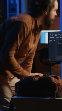 Freelancing system administrator arriving in personal office at home, resuming work on coding. IT expert starting job in apartment, writing lines of code on computer, camera A