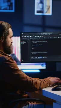 Experienced programmer writing code on computer screen while in office using java programming languages. Developer working on fixing database errors while working from home, camera A