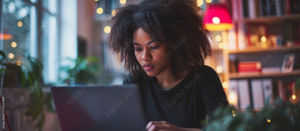 Poster a woman is seated at a table in a room, engrossed in using her laptop. she is having fun while atten