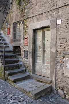 Vintage door, stone stairs, textured wall in old European alley.