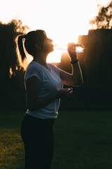 The importance of water balance during sports. Portrait of a girl drinking water on the background...