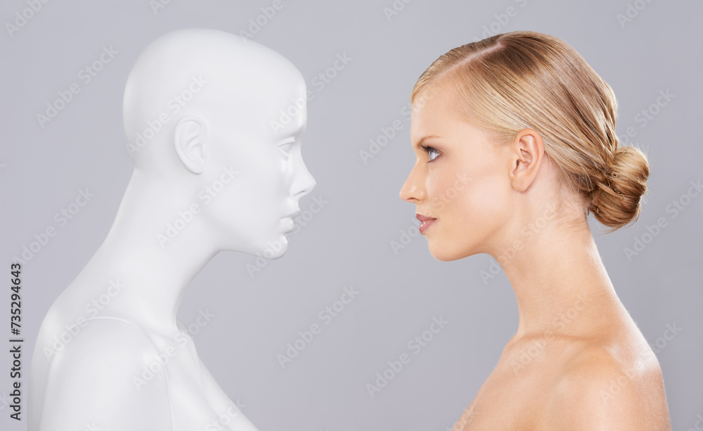 Canvas Prints Studio, woman and mannequin with beauty clone versus artificial standard, perfect and facial wellness. Girl, doll and face in profile for cosmetics, plastic surgery or makeup on grey background.