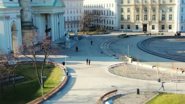 Square in front of Karlskirche cathedral, people walking by, tilt-shift effect; Austria, Vienna, 
