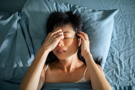 Young Asian woman waking up in the morning in her bed at home