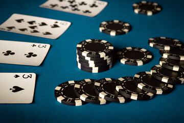 Playing cards and winning chips on a blue table in a poker club. Concept of winning a combination of cards from two pairs