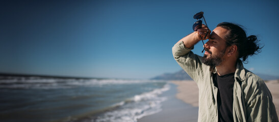 A young man is relaxing on a sandy sea beach.