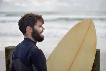 Man, surfboard and exercise at beach on vacation, weekend and sports for fitness in water. Happy male person, hobby and island for ocean waves, wetsuit and traveling on holiday or getaway for peace