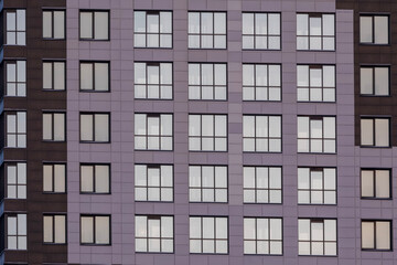 Fototapeta na wymiar five rows of windows on the facade of a modern apartment building