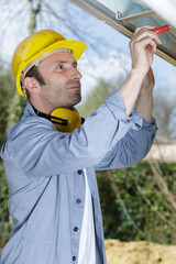 man fitting a pvc window outdoor