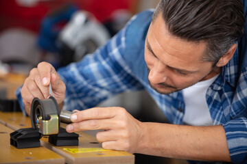 close-up carpenter process of wood door hinge installation