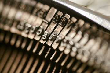 Closeup of old typewriter plates strikers strykers with letters and symbols for typing. - obrazy, fototapety, plakaty