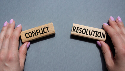 Conflict or Resolution symbol. Concept word Conflict or Resolution on wooden blocks. Businessman hand. Beautiful grey background. Business and Conflict or Resolution concept. Copy space