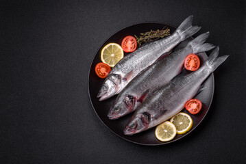 Fresh raw ocean sea bass fish with salt, spices and herbs