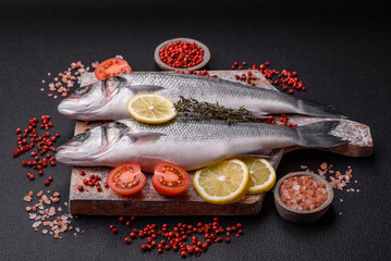 Fresh raw ocean sea bass fish with salt, spices and herbs
