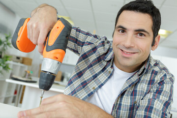 happy man holding a cordless drill do it yourself tool