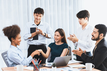 Diverse coworkers celebrate success with handshake and teamwork in corporate workplace....