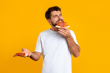 guy enjoys taste of pizza savoring junk food in studio