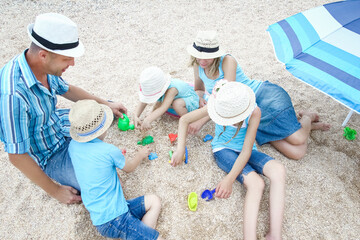 A Happy family playing by the sea shore on the sand background