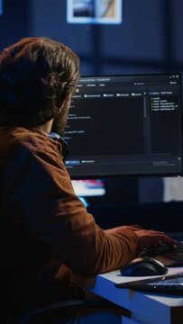 Software programmer taking break from coding, putting headphones on and stretching on desk chair during remote job shift. IT professional pausing tasks, listening music, loosening up, camera A
