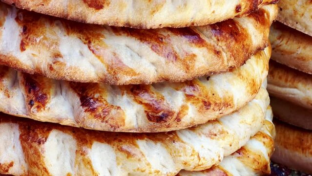 Tortillas on the market in Samarkand, Uzbekistan - June 29, 2023: Goods and traders at the Oriental Bazaar in Uzbekistan. Siab Bazaar is the largest and oldest bazaar in Samarkand. 4K