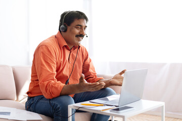 Middle aged indian man attending online webinar from home