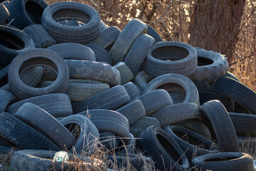 A pile of used tires abandoned in nature. Used tires pollution.