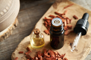 Fototapeta na wymiar Bottles of essential oil with red sandalwood chips