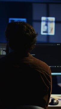 Man doing IT support job from home office, stretching after sitting on desk chair all day. Programmer loosening up, relaxing after typing on computer for long period of time, camera B