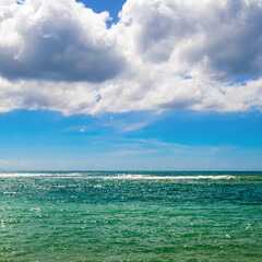 Fototapeta na wymiar Scenic tropical beach and sky with cumulus clouds.