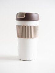 close-up of a white and brown thermal mug for drinks on a white background. Front view