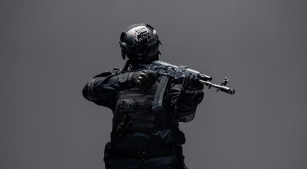 Soldier in black uniforms with weapon gun in studio. Banner Military army concept