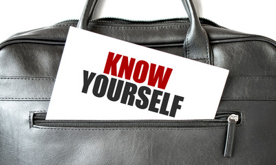 Text KNOW YOURSELF writing on white paper sheet in the black business bag. Business concept - obrazy, fototapety, plakaty
