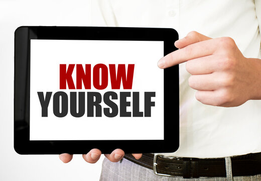 Text KNOW YOURSELF on tablet display in businessman hands on the white background. Business concept