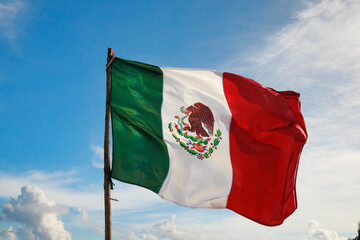 Naklejka na ściany i meble bandera de México con un cielo azul de fondo