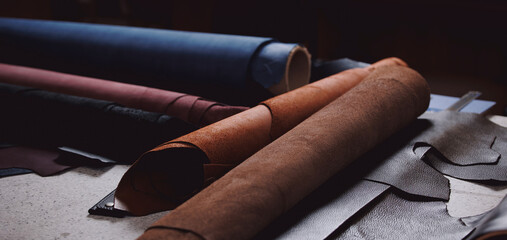 Banner Tailor on background different rolls natural brown leather, top view