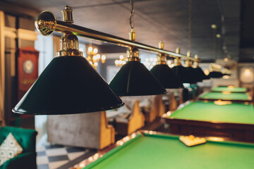lamp over billiards green table balls and cues.