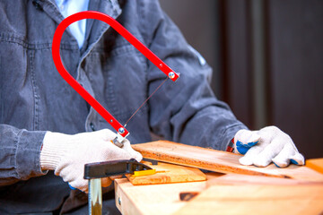 A man carves wood with a jigsaw.