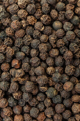 Dry black peppercorns background. Aromatic, organic spice. Top view.